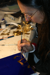 Michelle works on the applicatio of the gold leaf for the inscription